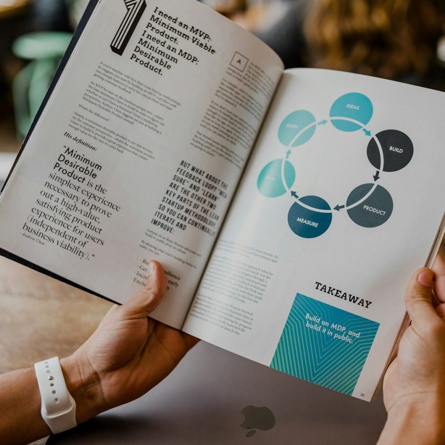 Skill Loop Collective Service Page Hands holding an open book displaying text and a circular diagram.